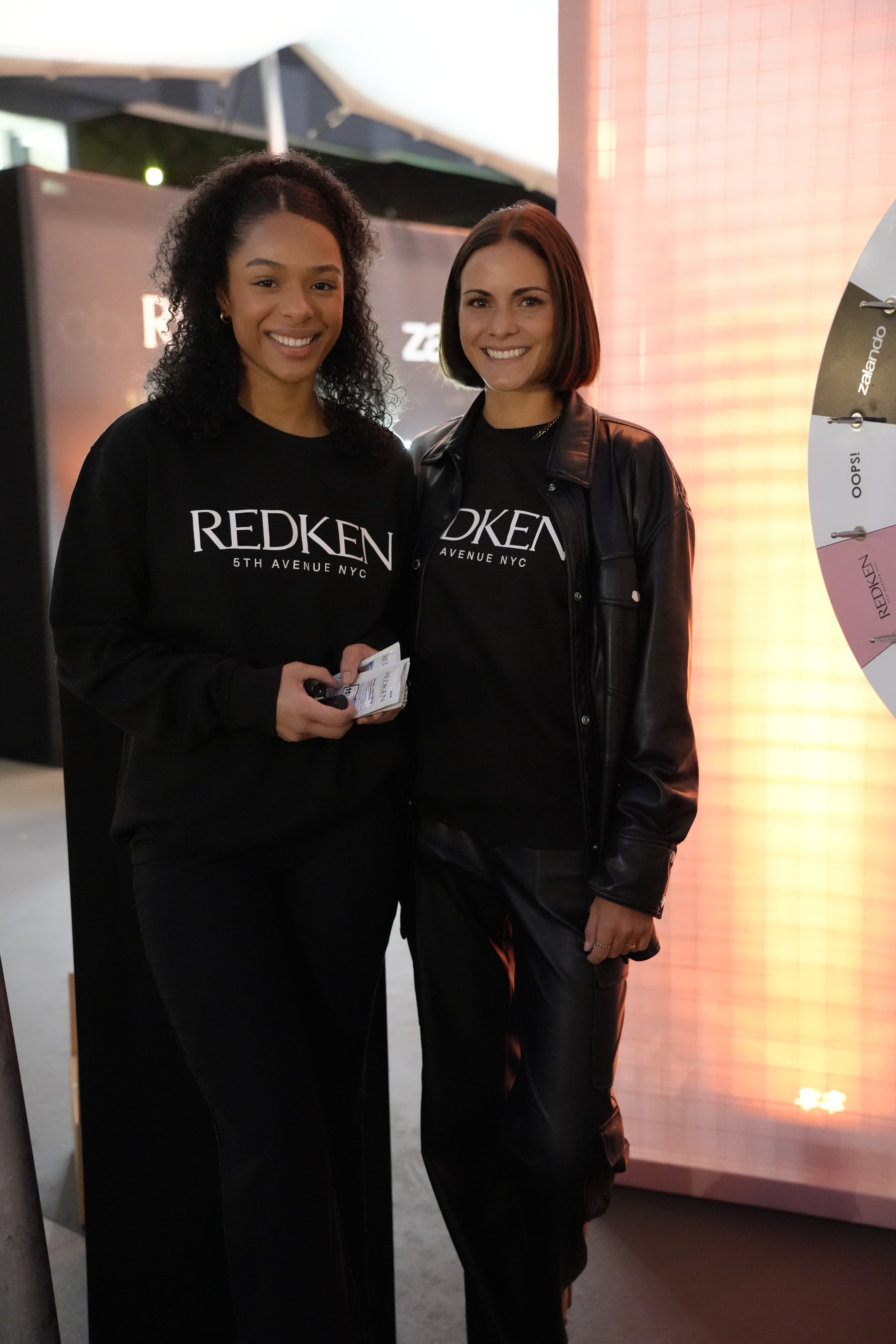 Promoterinnen vor einer Markenwand bei einem Redken Auftritt